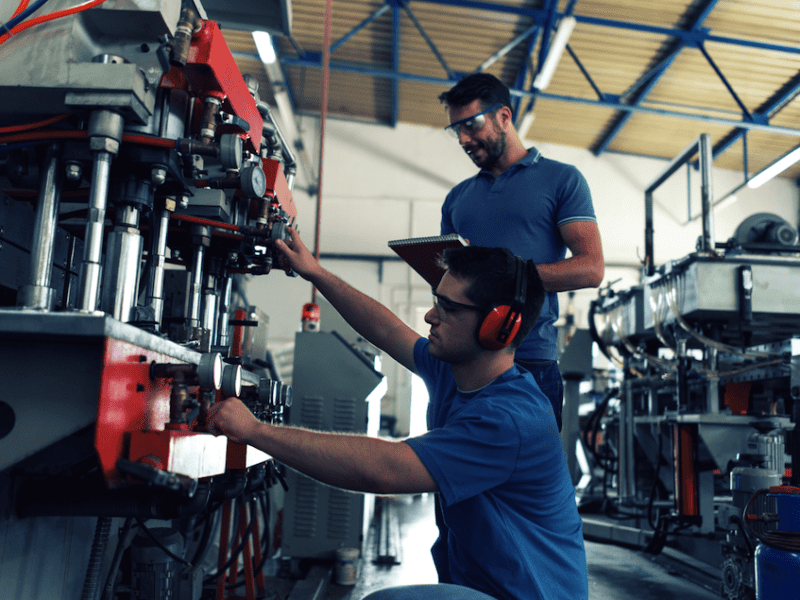A pair of experts working on industrial machinery.