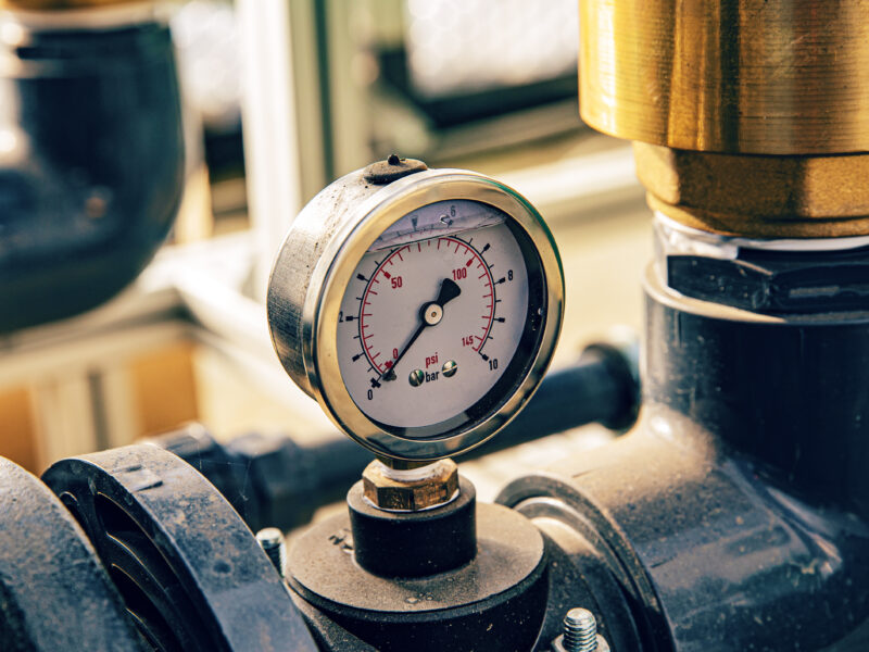 pressure-gauge-on-industrial-pipe-system-close-up